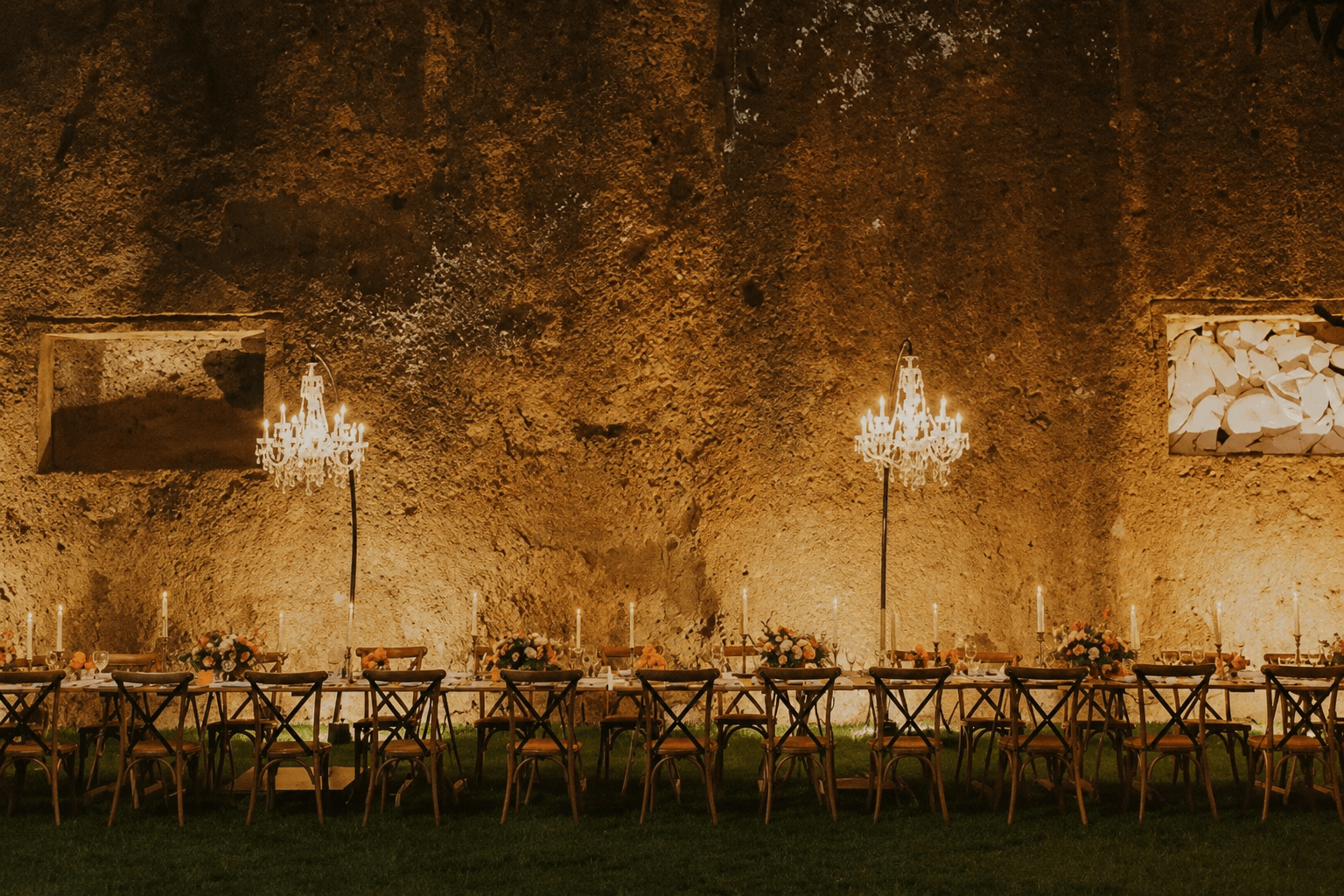 Mesa larga de la Residenza Antica Flaminia con chandeliers y velas al atardecer